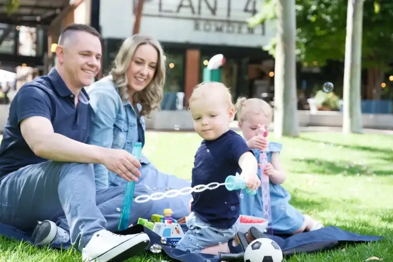 Erin and Adam, MyBudget clients, in the park with their family