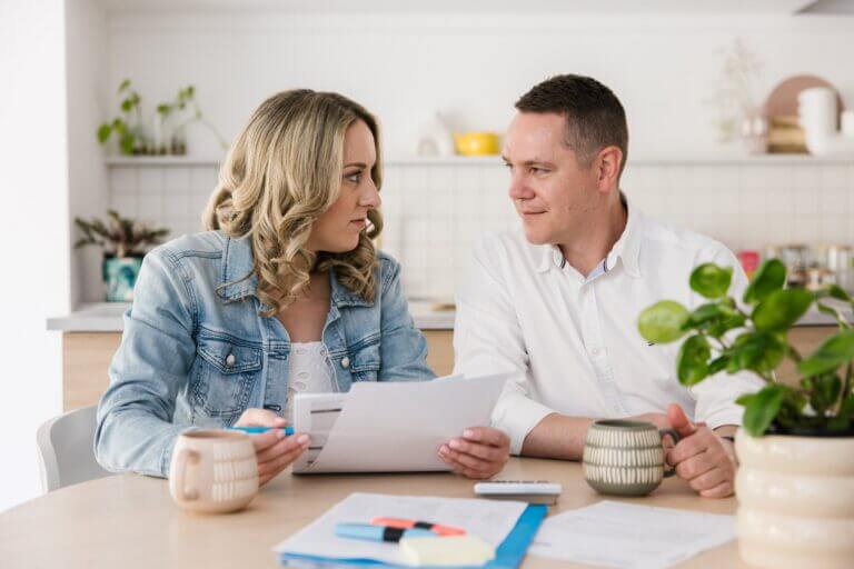MyBudget clients Adam and Erin budgeting at the kitchen table and reducing their financial stress